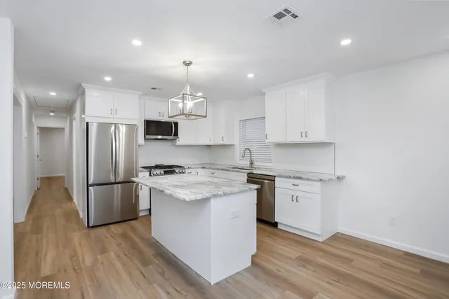a kitchen with a stove a refrigerator and a sink