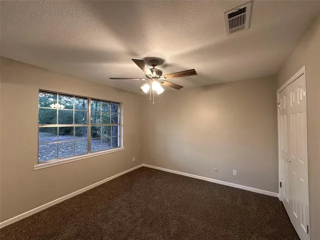 an empty room with a window and a fan