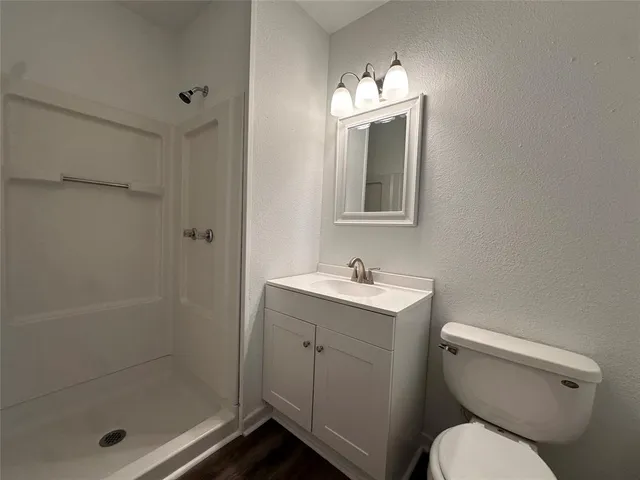 a bathroom with a toilet sink vanity and mirror