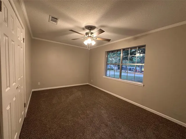 en empty room with windows and ceiling fan