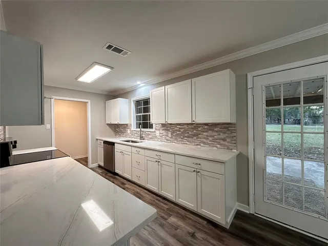a kitchen with granite countertop a sink stainless steel appliances and cabinets