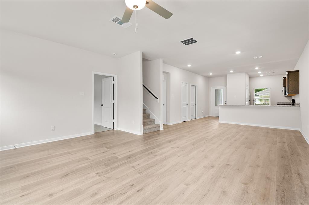 201 Southgate Drive Terrell, TX 75160 - Photo 2 of 5 an empty room with wooden floor kitchen view and a window