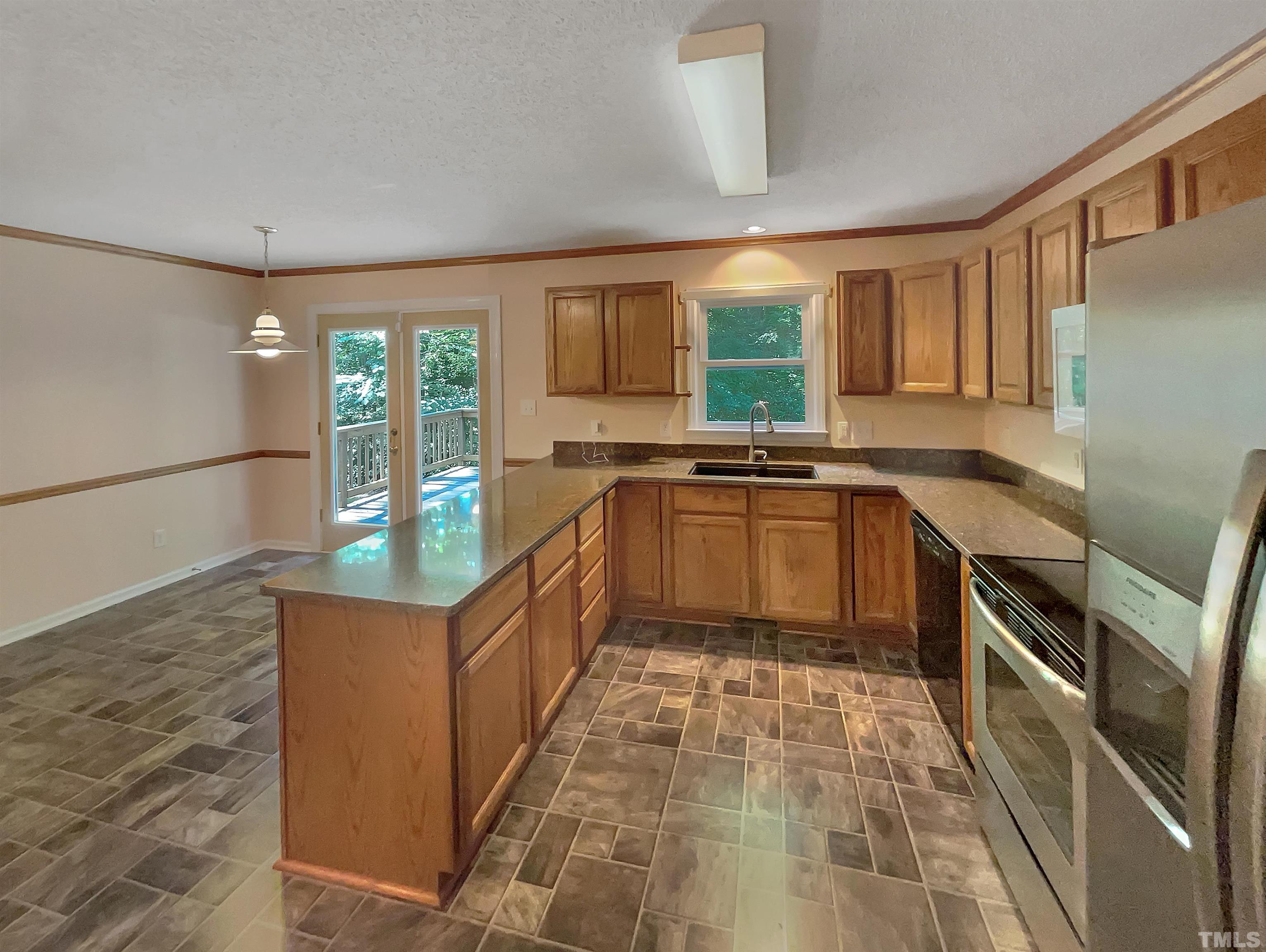 5225 Knightsbridge Way Raleigh, NC 27604 - Photo 4 of 21 a kitchen with stainless steel appliances granite countertop a sink and wooden cabinets