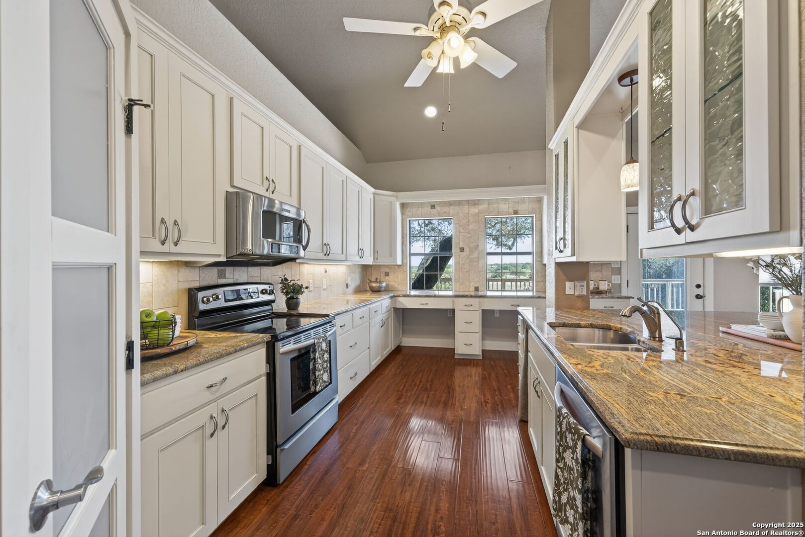 905 Cypress Pass Road Spring Branch, TX 78070 - Photo 14 of 42 a kitchen with stainless steel appliances granite countertop a sink dishwasher stove and white cabinets with wooden floor