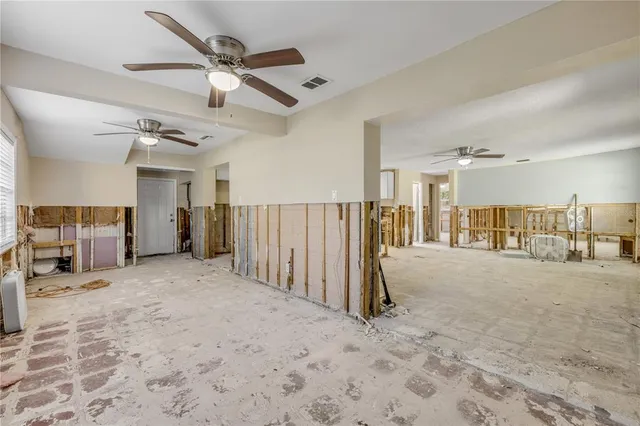 a view of a livingroom with wooden floor and a ceiling fan