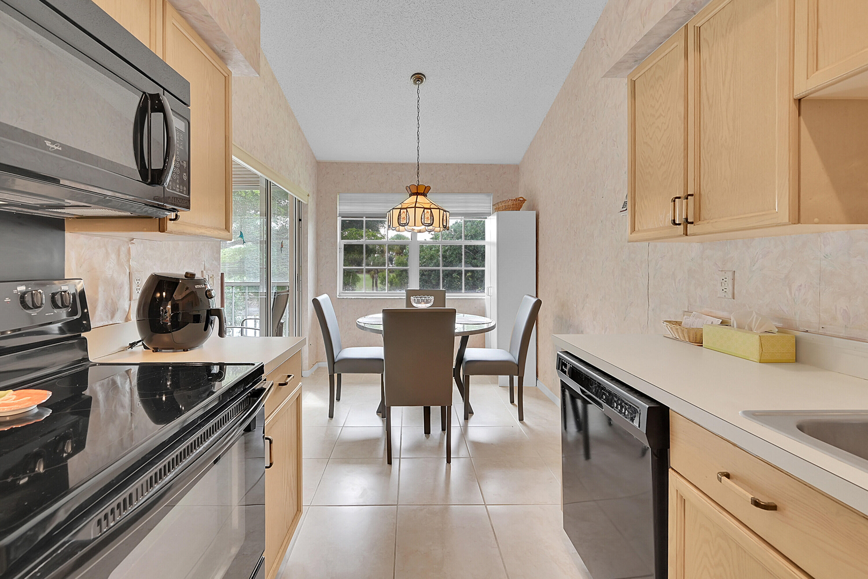 17270 Boca Club Boulevard, Unit 1702 Boca Raton, FL 33487 - Photo 14 of 41 a kitchen with stainless steel appliances granite countertop a stove a sink a microwave and dining table