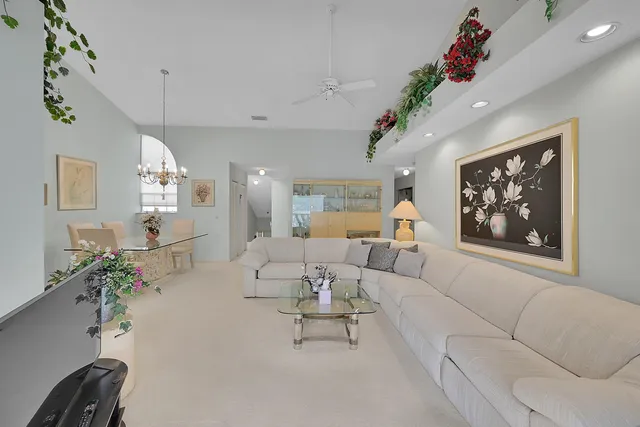 a living room with furniture flowers and a chandelier