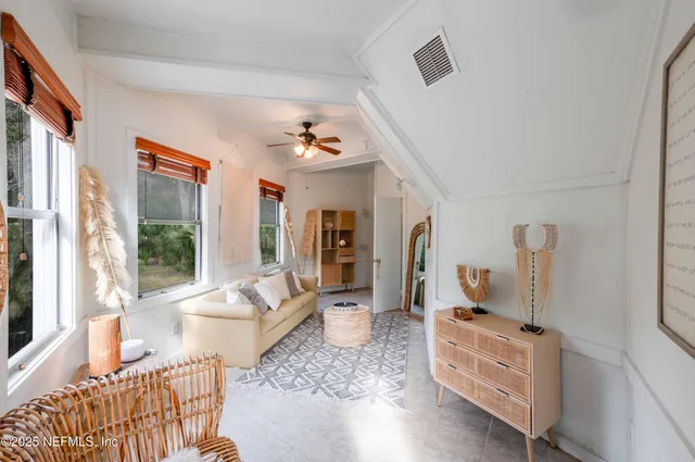a living room with furniture and a floor to ceiling window