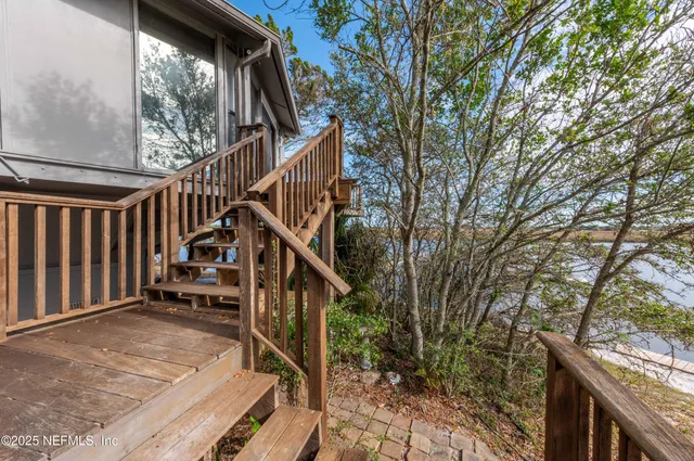 a view of a balcony with wooden floor and fence