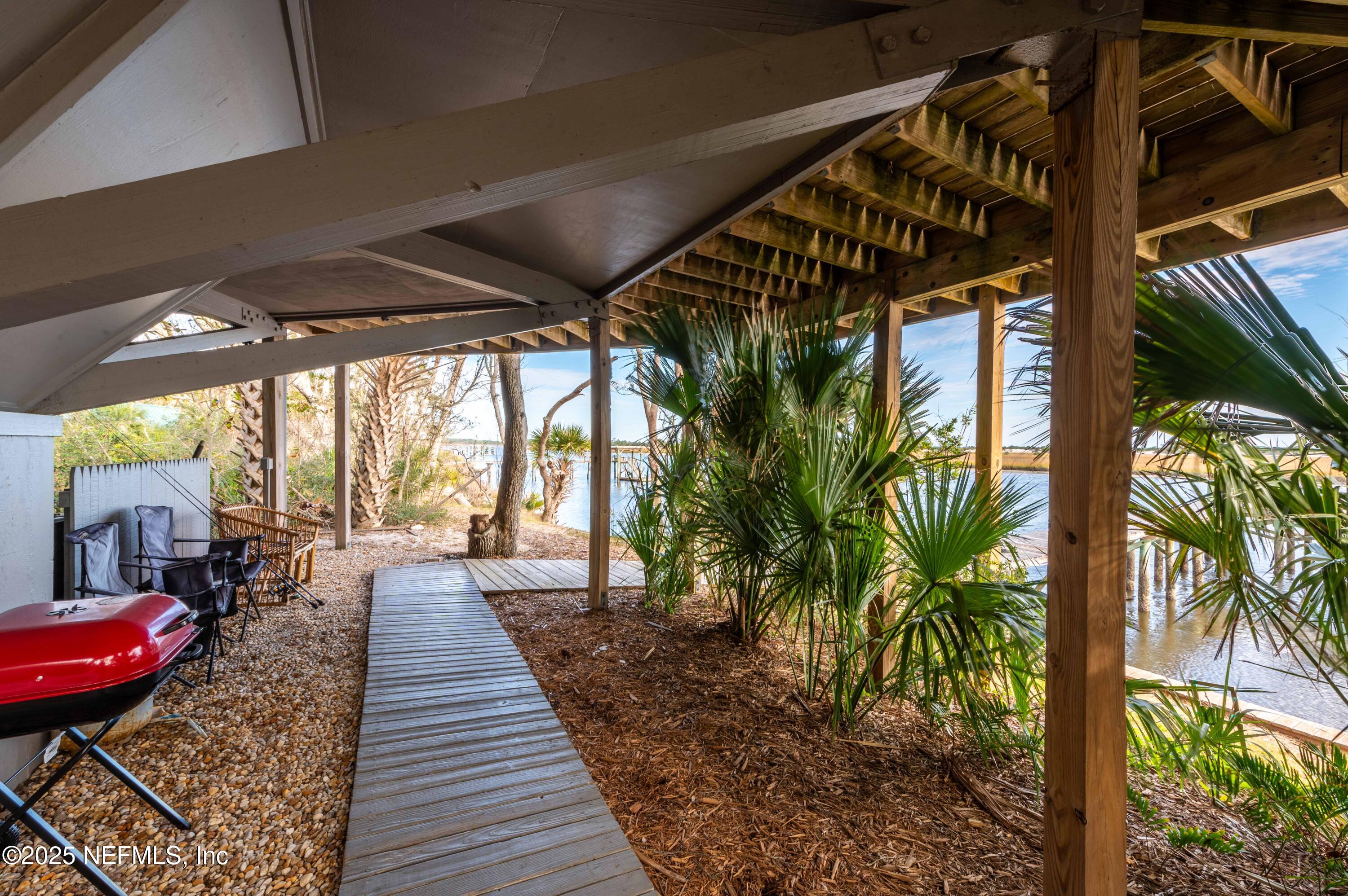 11255 Fort George Road Jacksonville, FL 32226 - Photo 9 of 38 a view of a patio with table and chairs potted plants and floor to ceiling window