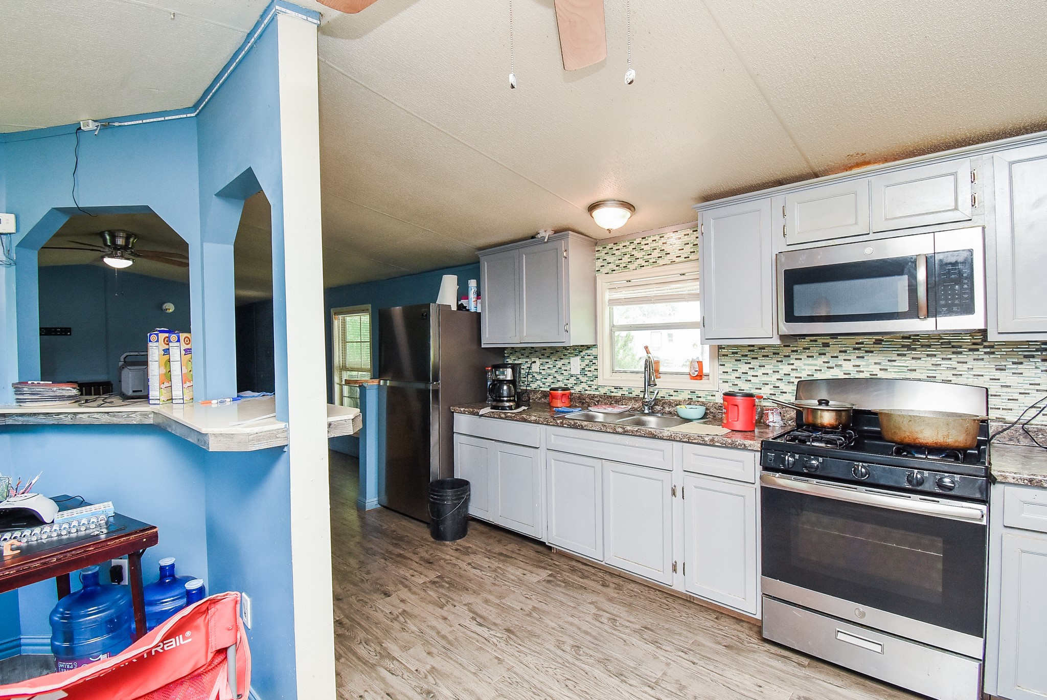 39551 Donigan Road Brookshire, TX 77423 - Photo 36 of 37 a kitchen with stainless steel appliances granite countertop a stove a sink and a microwave