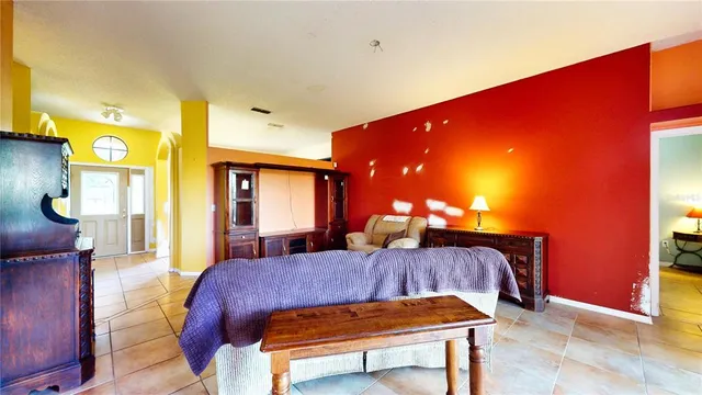 a living room with a table chairs and a refrigerator