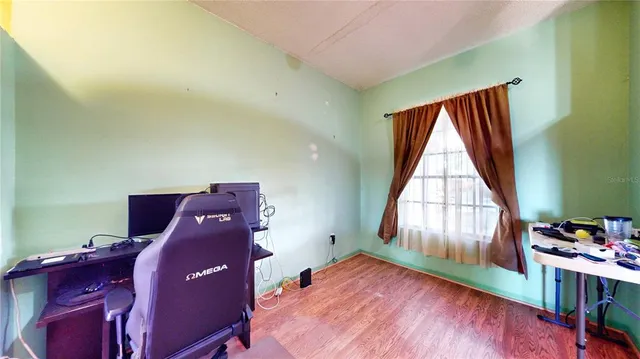 a view of a workspace with furniture and a window