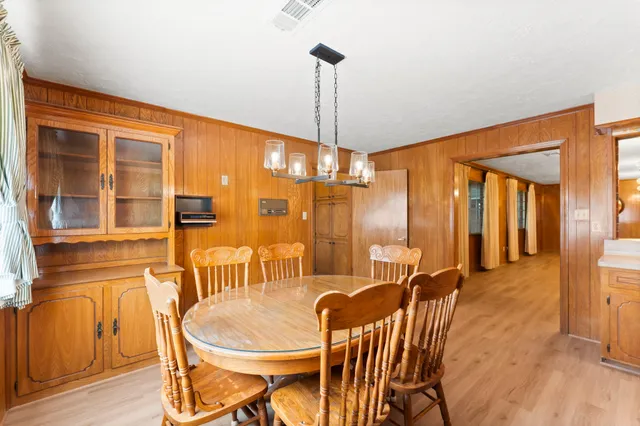 a dining room with furniture a chandelier and wooden floor