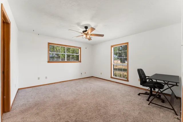 a view of a workspace with furniture and a window