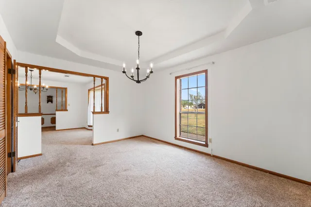 a view of a big room with windows and chandelier