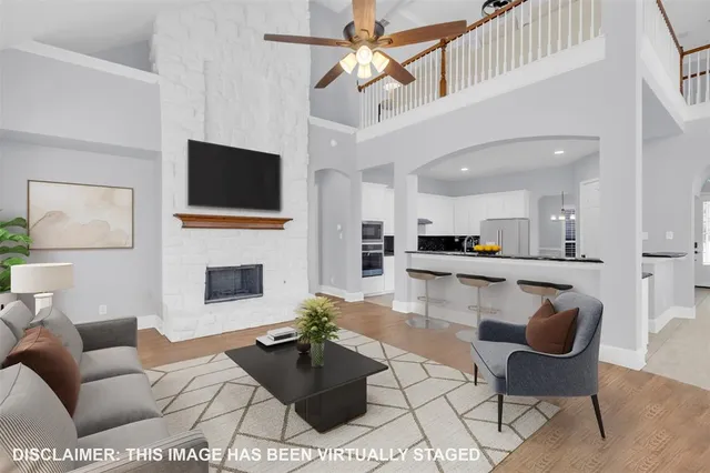 a living room with furniture a flat screen tv and kitchen view