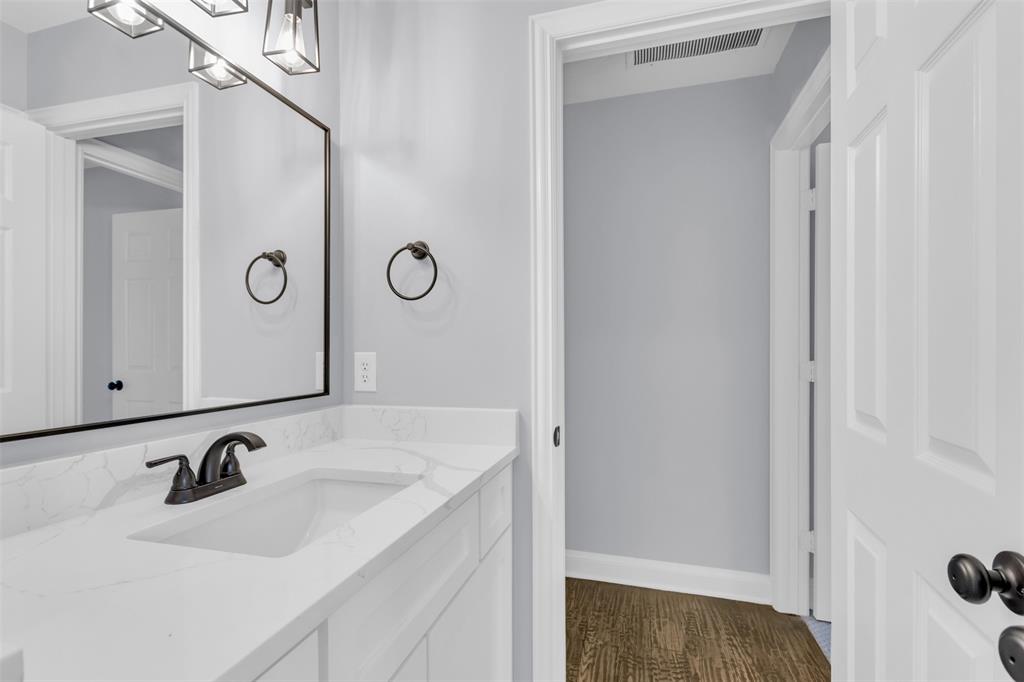 4306 Mitchell Lane Rowlett, TX 75088 - Photo 31 of 39 Bathroom featuring dark wood finished floors and vanity