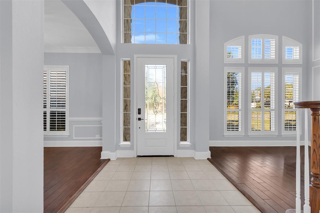 4306 Mitchell Lane Rowlett, TX 75088 - Photo 7 of 39 Entryway with light wood finished floors, arched walkways, a towering ceiling, and crown molding