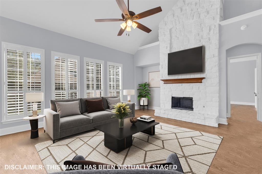 4306 Mitchell Lane Rowlett, TX 75088 - Photo 10 of 39 Living area with a stone fireplace, high vaulted ceiling, ceiling fan, light wood-style floors, and arched walkways