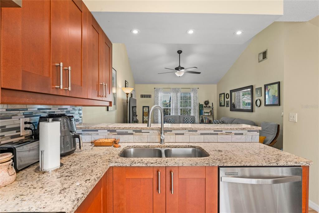 6424 Spring Flower Drive, Unit 24 New Port Richey, FL 34653 - Photo 11 of 66 a kitchen with stainless steel appliances granite countertop a sink a stove and a wooden cabinets
