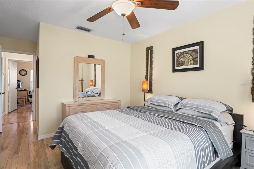 6424 Spring Flower Drive, Unit 24 New Port Richey, FL 34653 - Photo 16 of 66 a bedroom with a bed and wooden floor