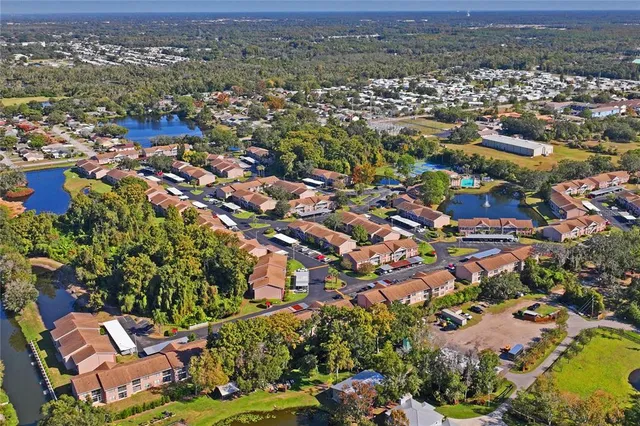 an aerial view of residential houses with outdoor space and trees all around
