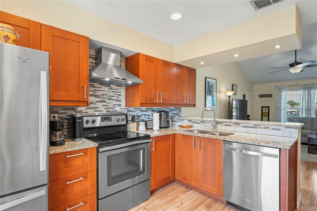 6424 Spring Flower Drive, Unit 24 New Port Richey, FL 34653 - Photo 10 of 66 a kitchen with stainless steel appliances granite countertop a stove a sink and a refrigerator