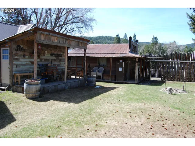 a backyard of a house with barbeque oven table and chairs