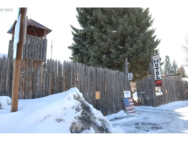 a view of wooden fence under a large tree