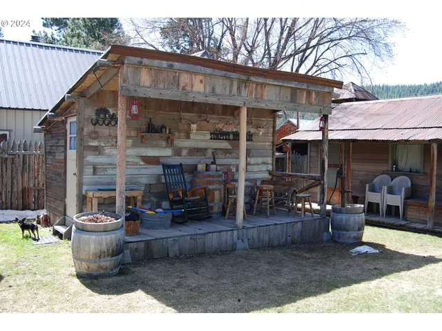 a view of a patio with table and chairs and wooden fence