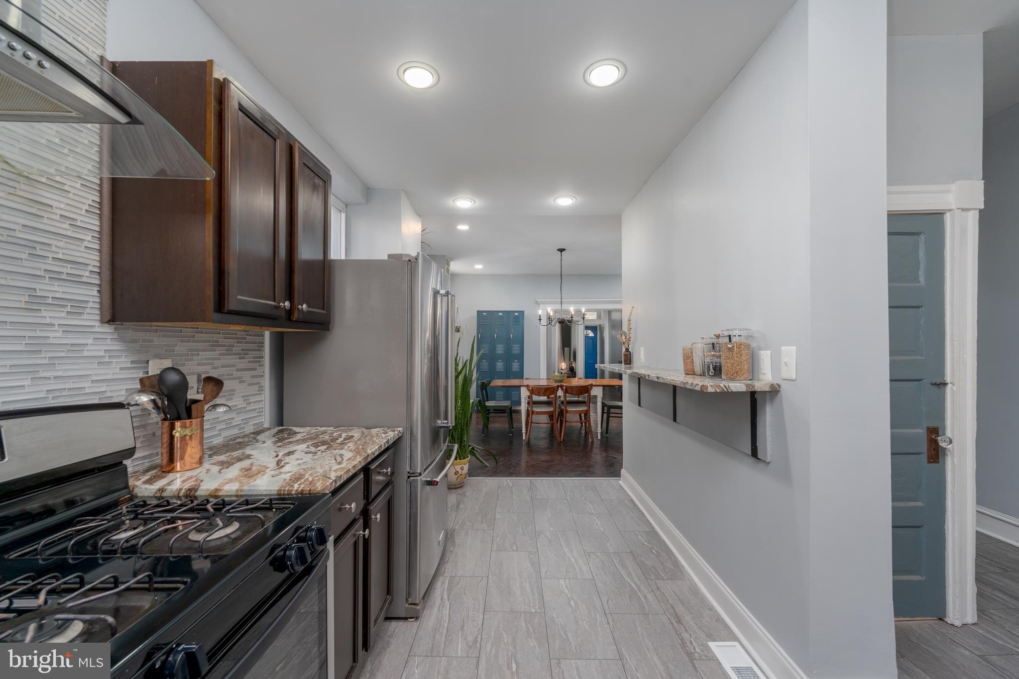 2512 Brookfield Avenue Baltimore, MD 21217 - Photo 12 of 35 a kitchen with stainless steel appliances kitchen island granite countertop a stove a sink and a refrigerator