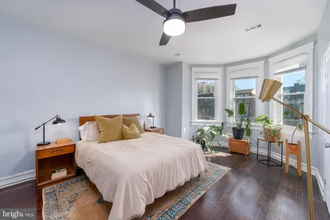 a bedroom with bed and wooden floor