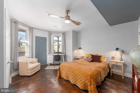 a bedroom with a bed and wooden floor