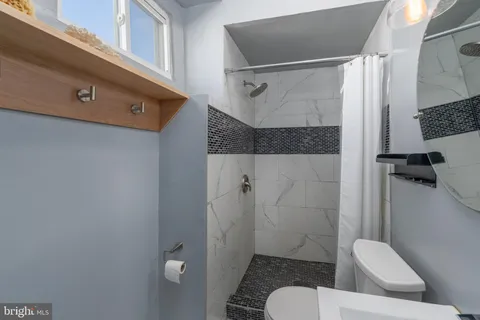 a bathroom with a shower a toilet and a sink
