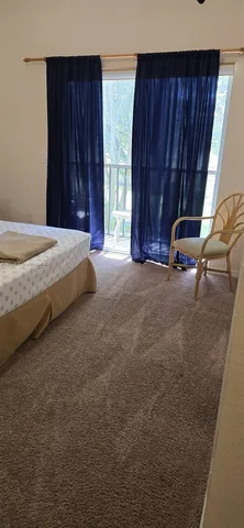 a bed sitting in a spacious bedroom next to a window