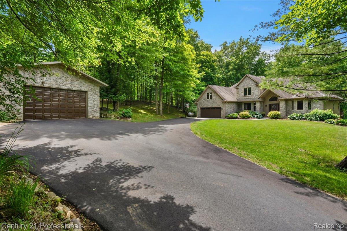 9867 Rainbow Ridge Drive Schoolcraft, MI 49087 - Photo 13 of 82 Spacious two-story residence featuring a stone exterior, an attached two-car garage, and an additional detached garage with a dark wood panel door