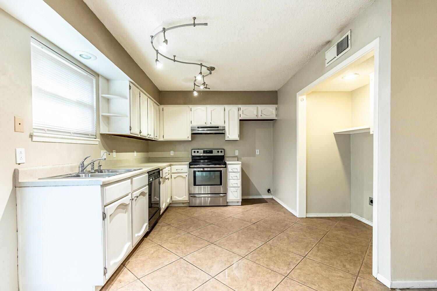 4737 48th Street Lubbock, TX 79414 - Photo 12 of 34 a kitchen with stainless steel appliances granite countertop a stove a sink and a refrigerator