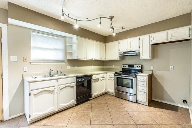 a kitchen with stainless steel appliances granite countertop a sink and cabinets