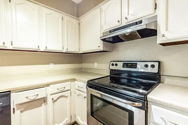 a kitchen with wooden cabinets and a stove top oven