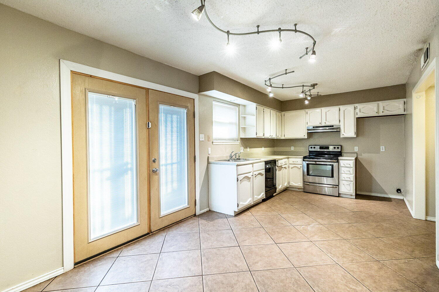 4737 48th Street Lubbock, TX 79414 - Photo 19 of 34 a kitchen with granite countertop a refrigerator and white cabinets