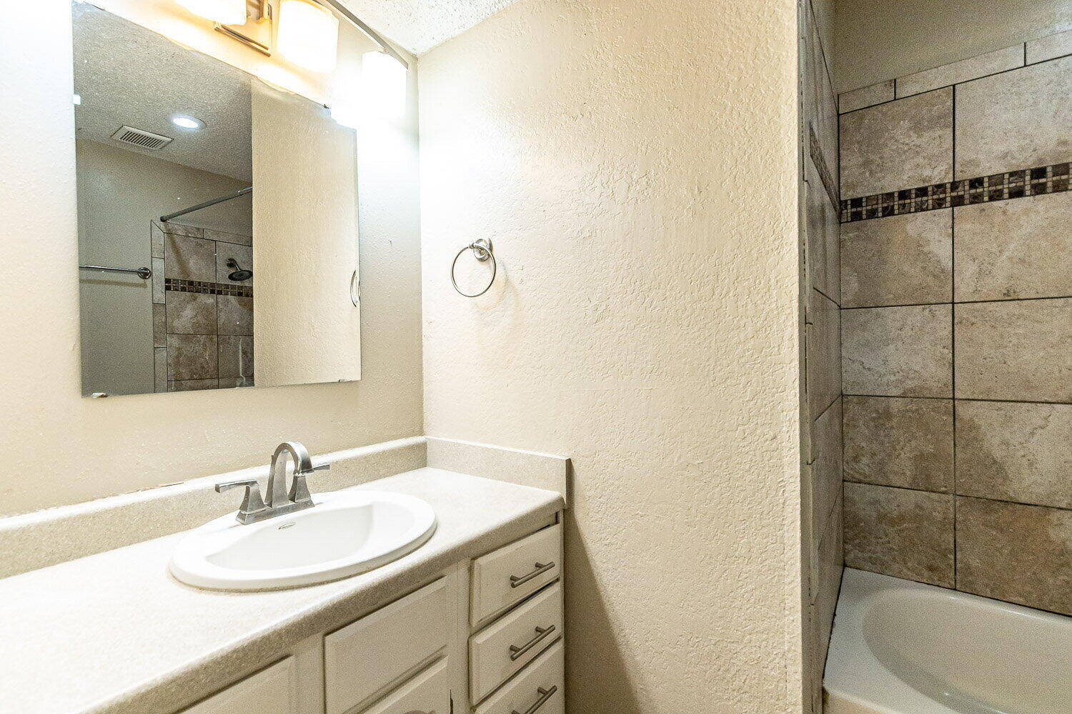 4737 48th Street Lubbock, TX 79414 - Photo 25 of 34 a bathroom with a granite countertop sink and a mirror