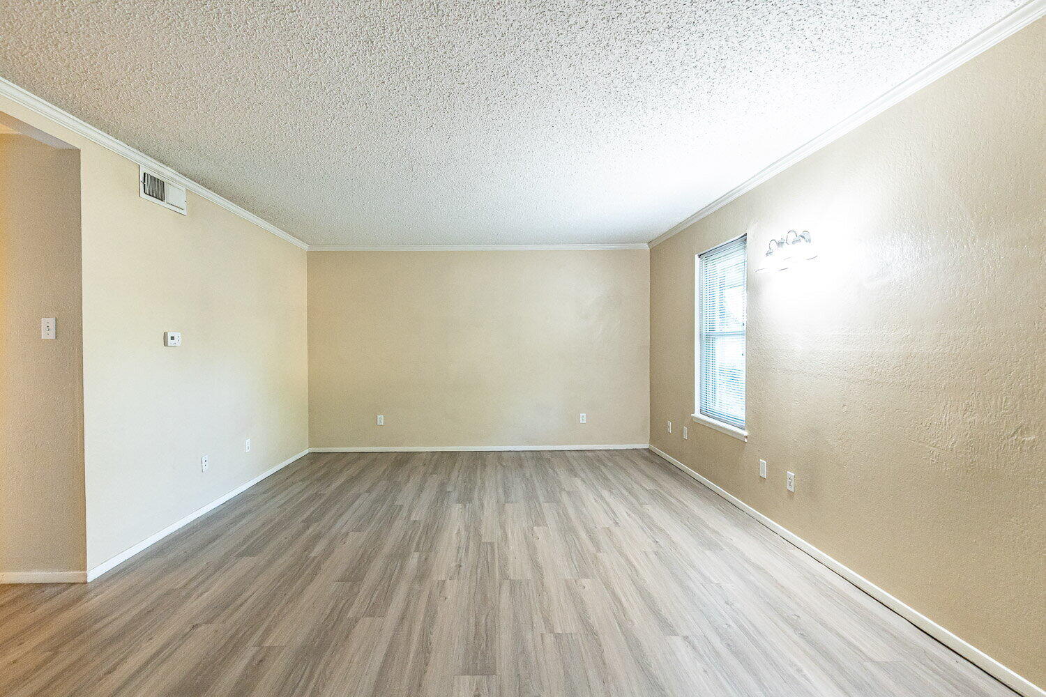 4737 48th Street Lubbock, TX 79414 - Photo 7 of 34 an empty room with wooden floor and windows