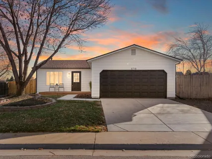 a front view of a house with garage and trees