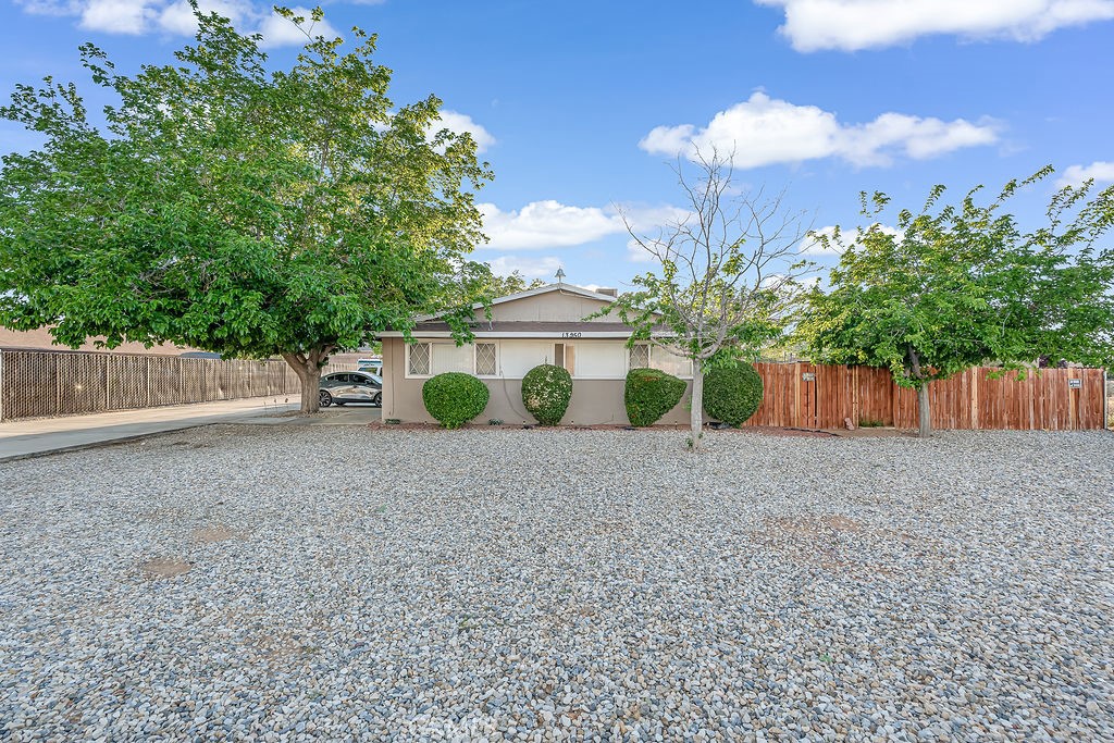 13250 Mohawk Road Apple Valley, CA 92308 - Photo 3 of 16 a view of a house with a yard and a large tree