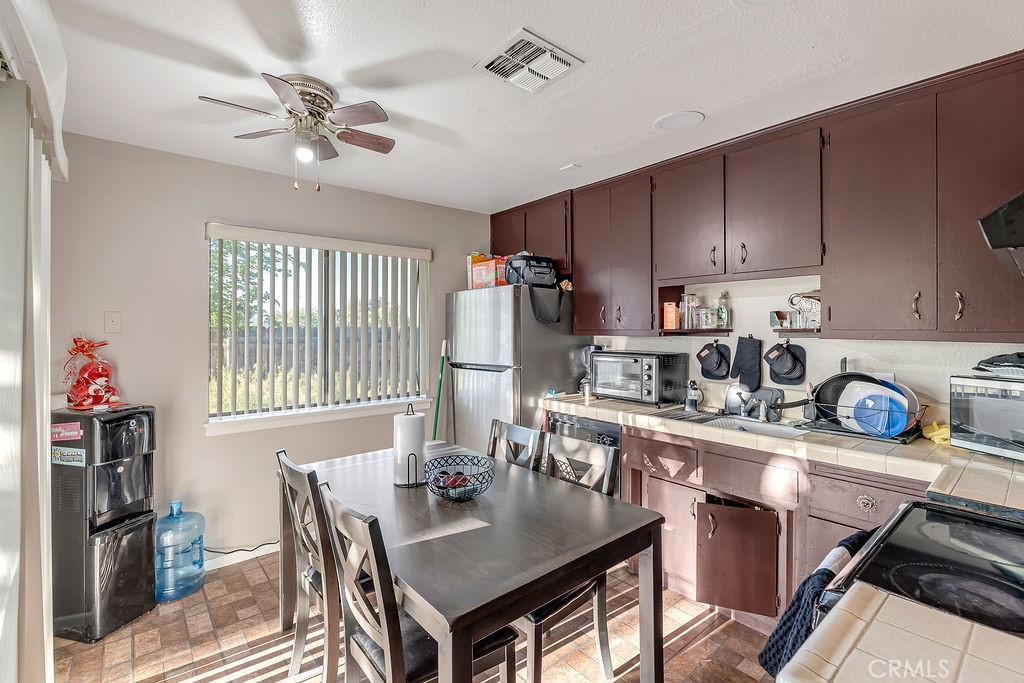 13250 Mohawk Road Apple Valley, CA 92308 - Photo 7 of 16 a kitchen with a dining table chairs and refrigerator