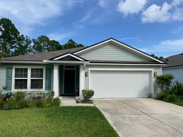 a front view of a house with a garden