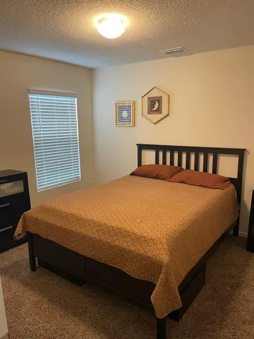 a spacious bedroom with a bed and a couch