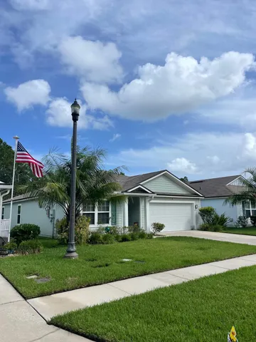 a front view of a house with a garden and yard