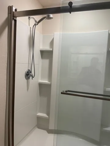 a white toilet sitting next to a shower